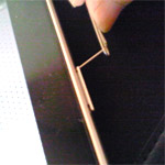 iPadのSIMカード取り外し方法、スリットカバーの穴にクリップを挿している場面